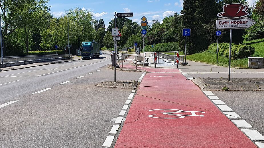An der Einmündung der Heiligenbergstraße in die Zeppelinstraße führt der Radweg im Zickzack durch die Absperrungen. Hier muss der Radweg dringend auf die Fahrbahn verlegt werden!