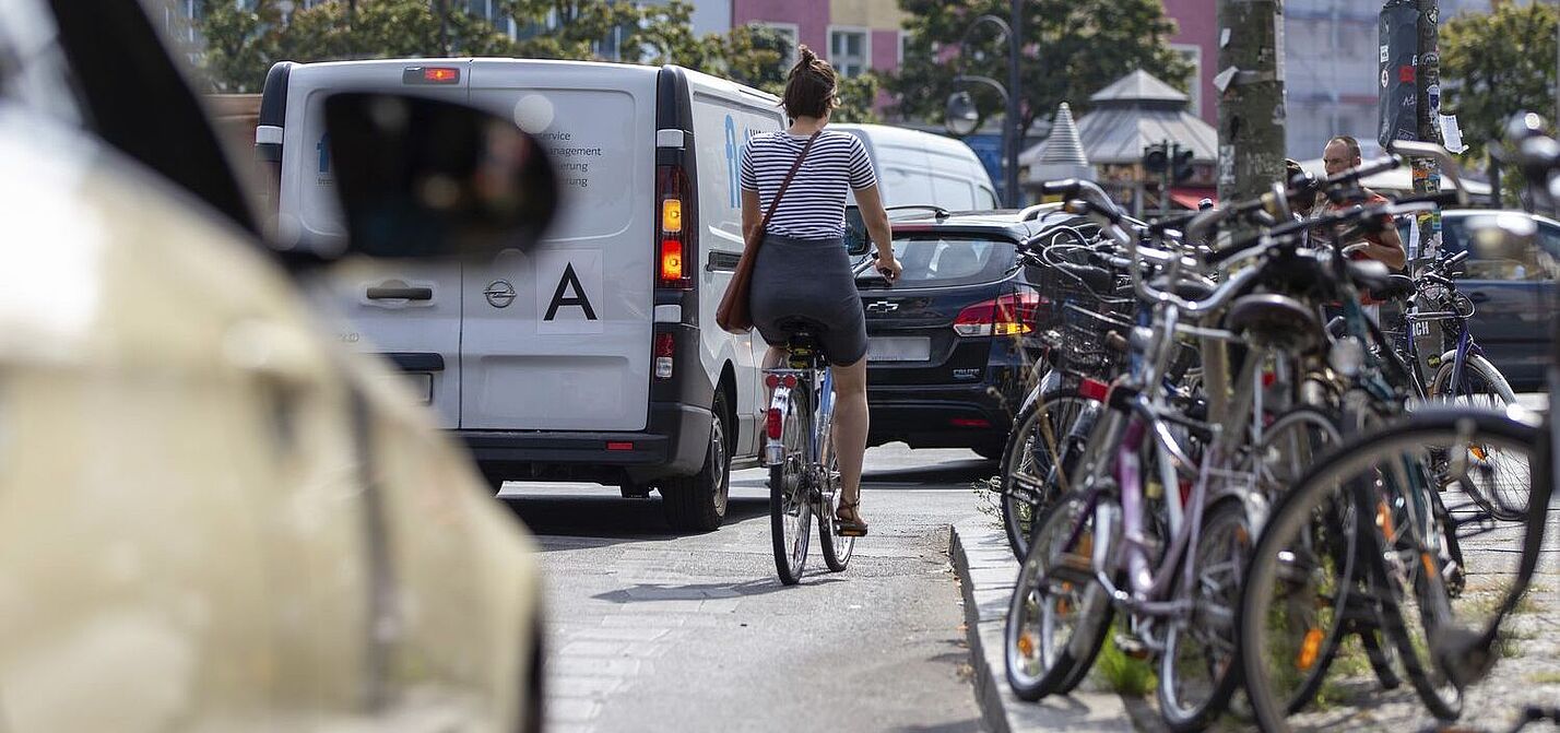 Aufmacher StVG-Buendnis Radfahrerin auf Fahrbahn, bedrängt von Kfz.
